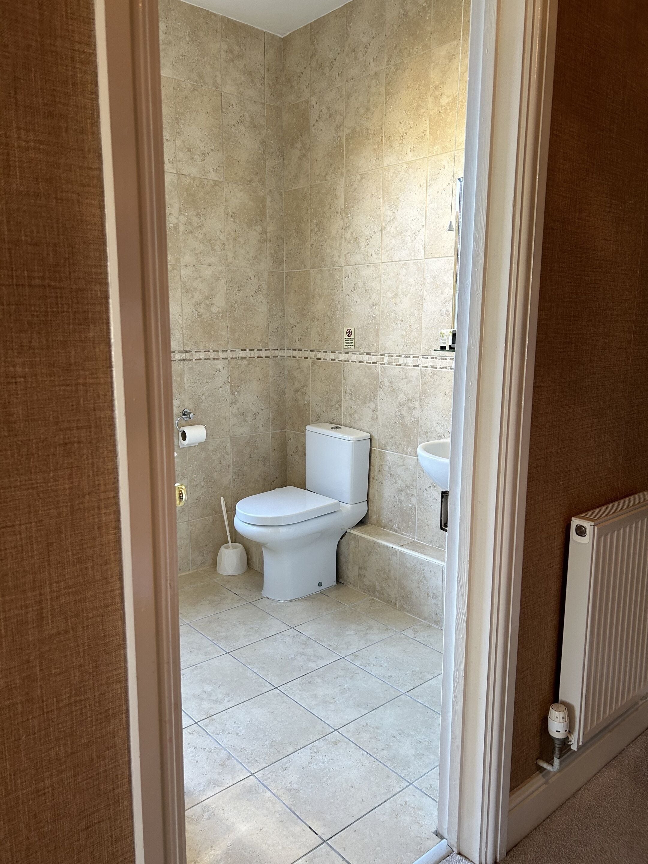 A bathroom with a toilet, a bidet, and a radiator.