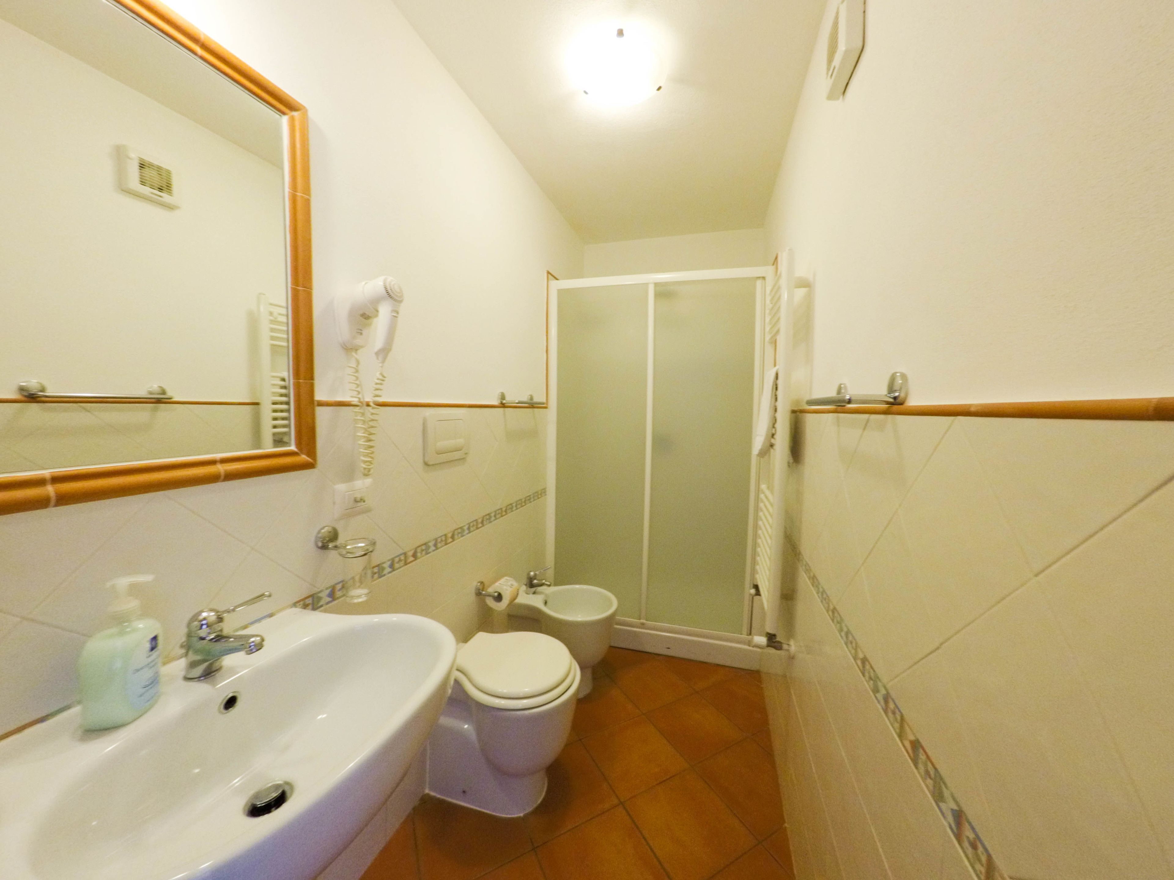 A bathroom with a sink, toilet, and shower.