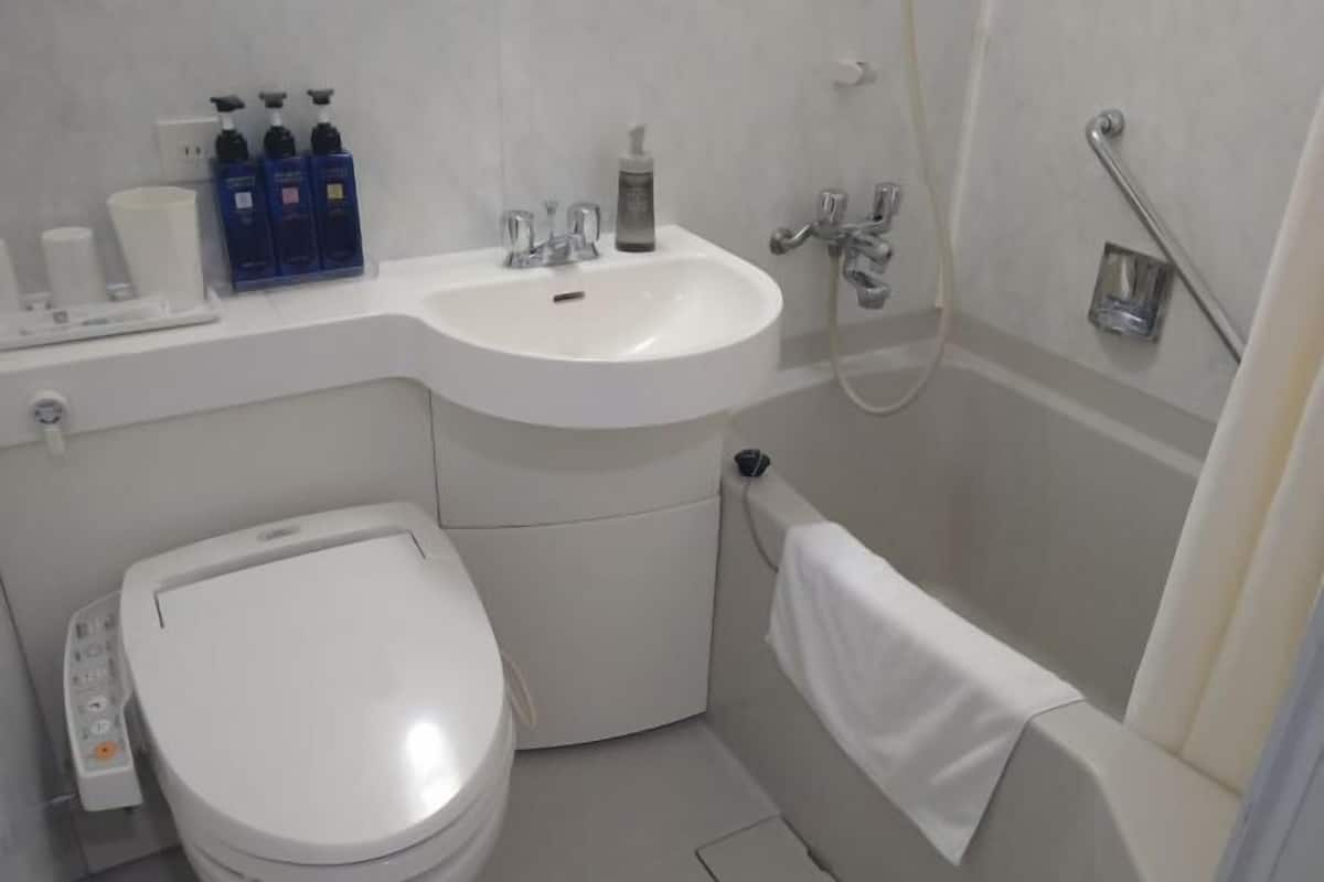 Duschwanne, Haartrockner, Hausschuhe, Toilette mit elektrischem Bidet