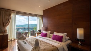 A hotel room with a large bed, a wooden headboard, a nightstand with a lamp, a chair, and a view of the outdoors. - The Swiss Residence (Kandy)