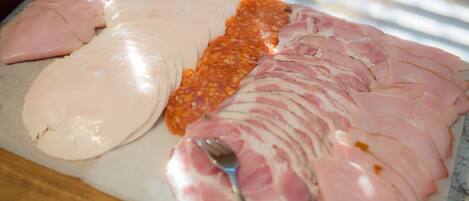 Una variedad de carnes cortadas sobre una tabla.