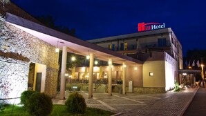 Un hotel con fachada de piedra, zona de estar al aire libre y un letrero que indica que es un hotel.