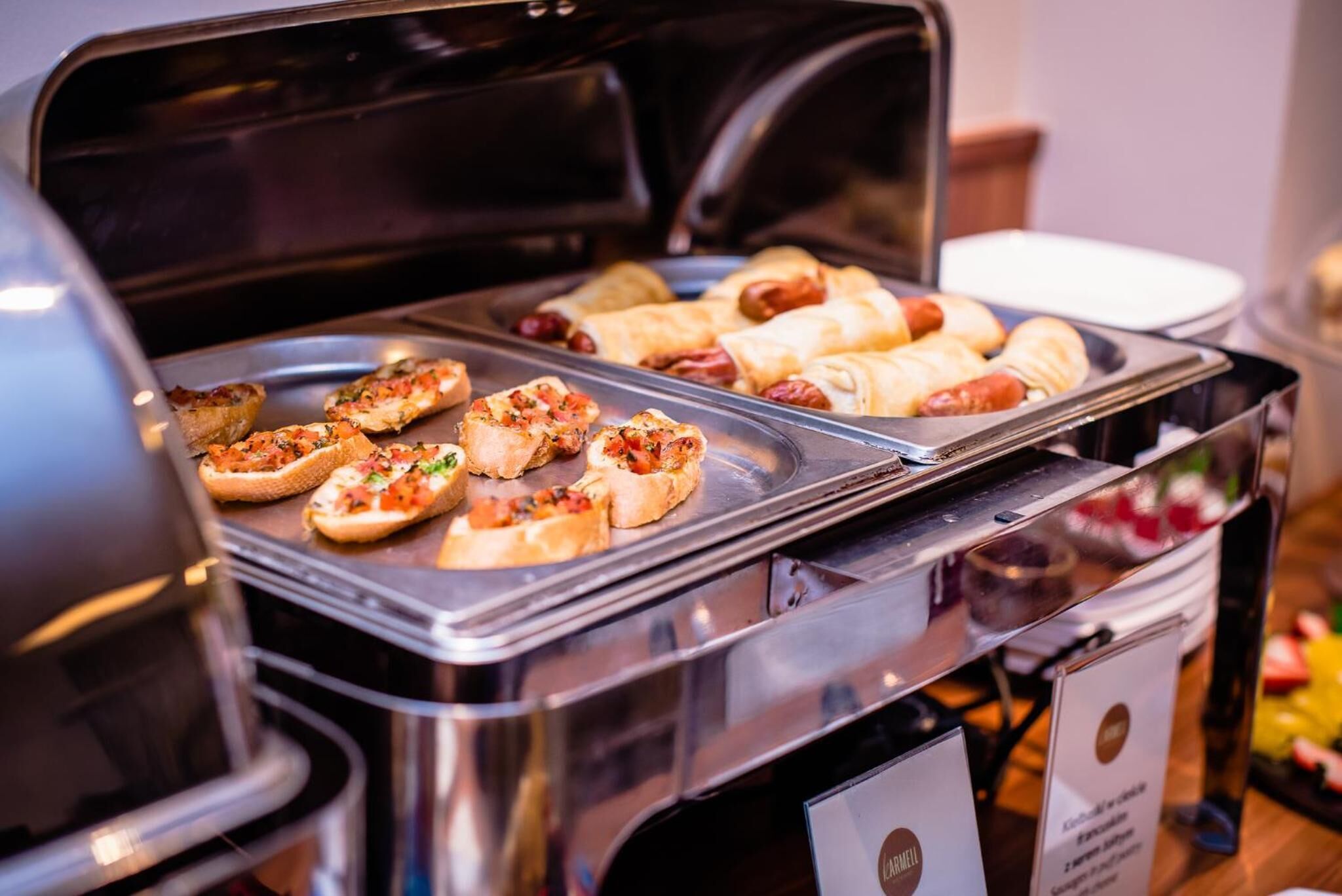 Een buffet met diverse gerechten, waaronder pizza's en hotdogs.
