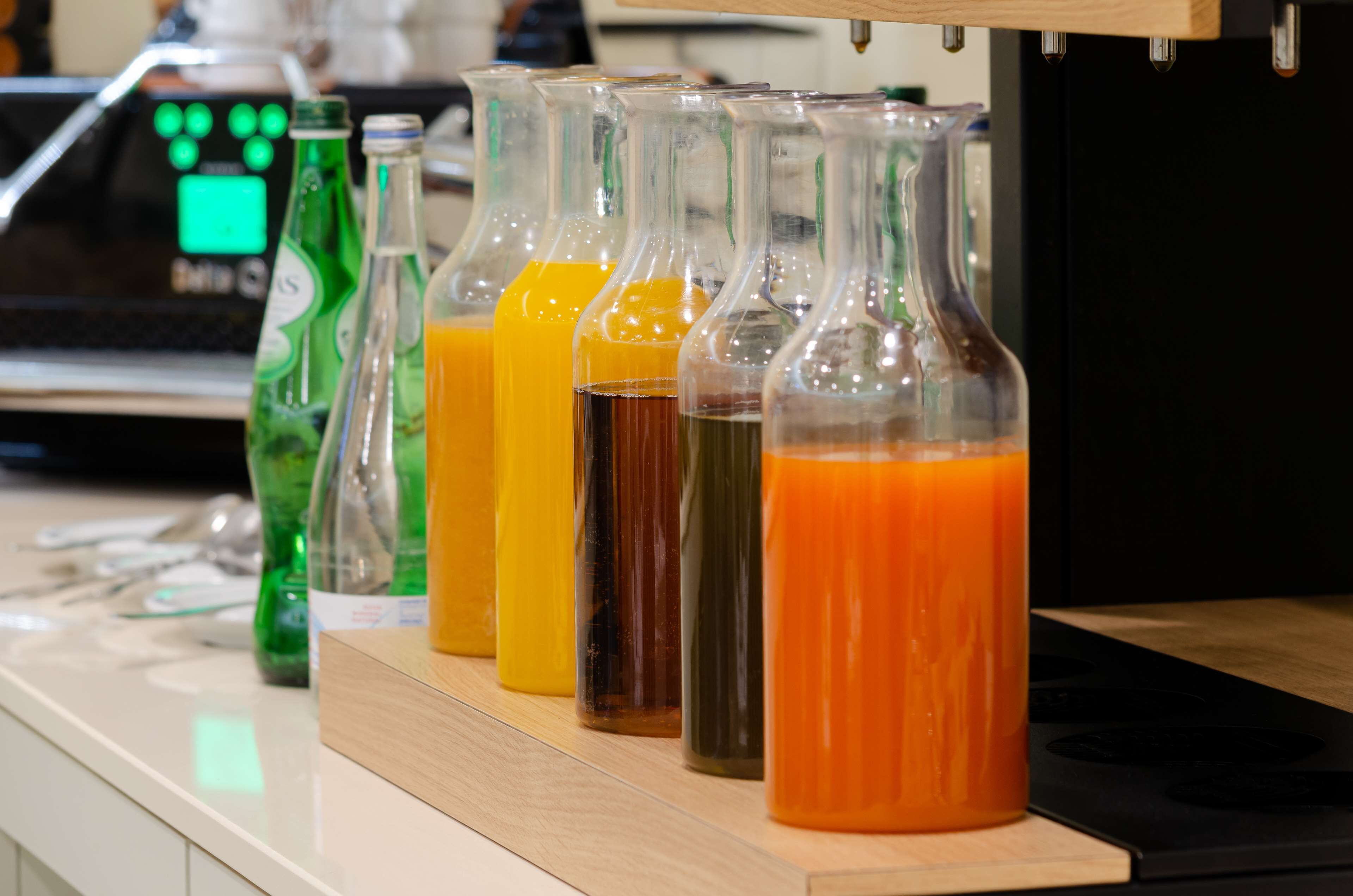 A row of glass bottles with different colored liquids on a countertop.