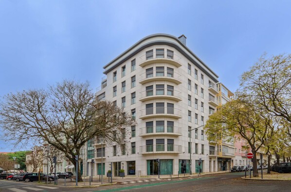 Un immeuble à plusieurs étages doté d’une façade incurvée, de grandes fenêtres et de balcons.