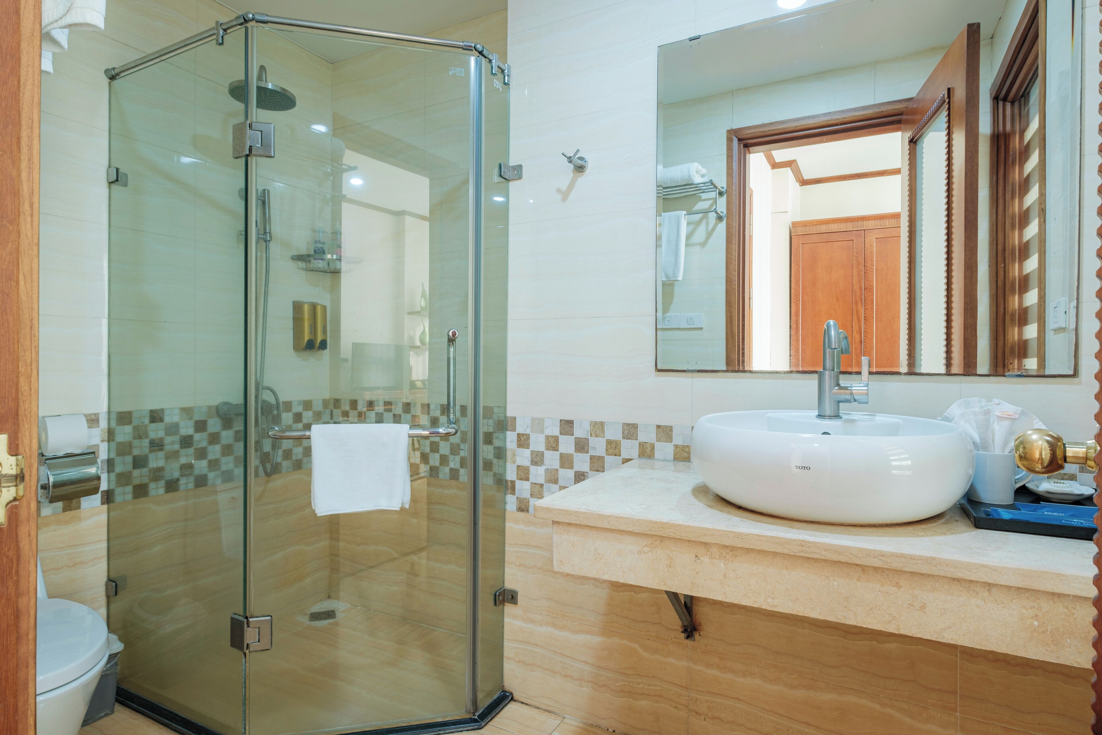A modern bathroom with a glass-enclosed shower, a white sink, and a large mirror.