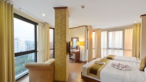 Habitación de hotel con dos camas, un escritorio y una silla.