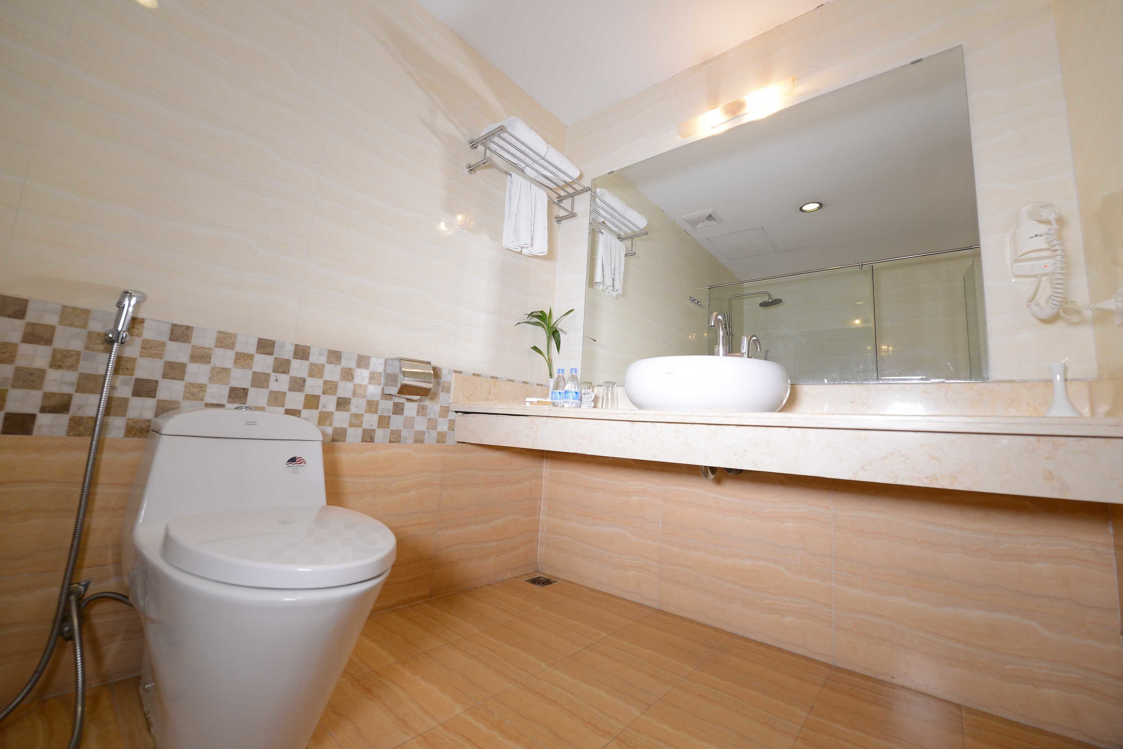 A modern bathroom with a toilet, sink, and shower.