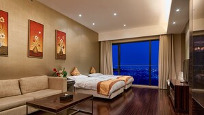 A modern hotel room with a large bed, a sofa, a coffee table, and a city view through the window. - Guangzhou Heefun Apartment - Poly World Trading (Guangzhou)