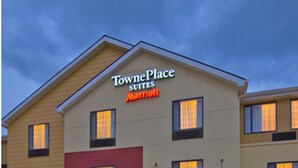 A TownePlace Suites hotel with a prominent sign, multiple windows, and outdoor seating area. - Towneplace Suites by Marriott Aiken Whiskey Road (Aiken)