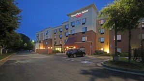 A TownePlace Suites hotel with a parking lot, marked handicapped spaces, and a black SUV parked in front. - Towneplace Suites by Marriott Aiken Whiskey Road (Aiken)