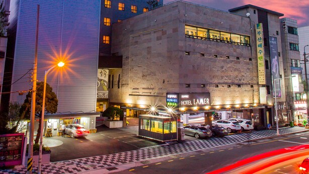 Un hôtel moderne, doté d’une enseigne bien visible, d’une entrée bien éclairée et d’un espace de stationnement.