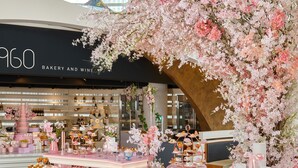 A bakery and wine shop with a pink and white color scheme, featuring a variety of pastries and desserts displayed on pink stands. - Sono Calm Goyang (Goyang)