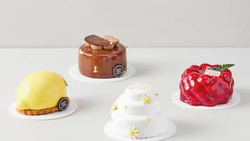 Four cakes on white plates.