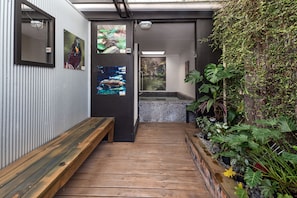 A wooden bench, a wall-mounted picture, a fish tank, and a planter with greenery. - Red Rock Thermal Motel (Rotorua)