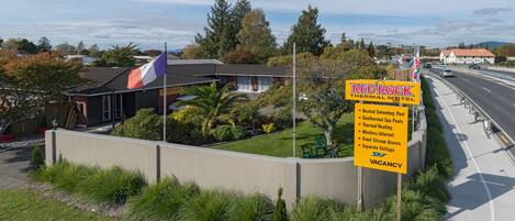 A motel sign with amenities including a heated swimming pool, geothermal spa, thermal heating, wireless internet, trout stream access, and a separate cottage.