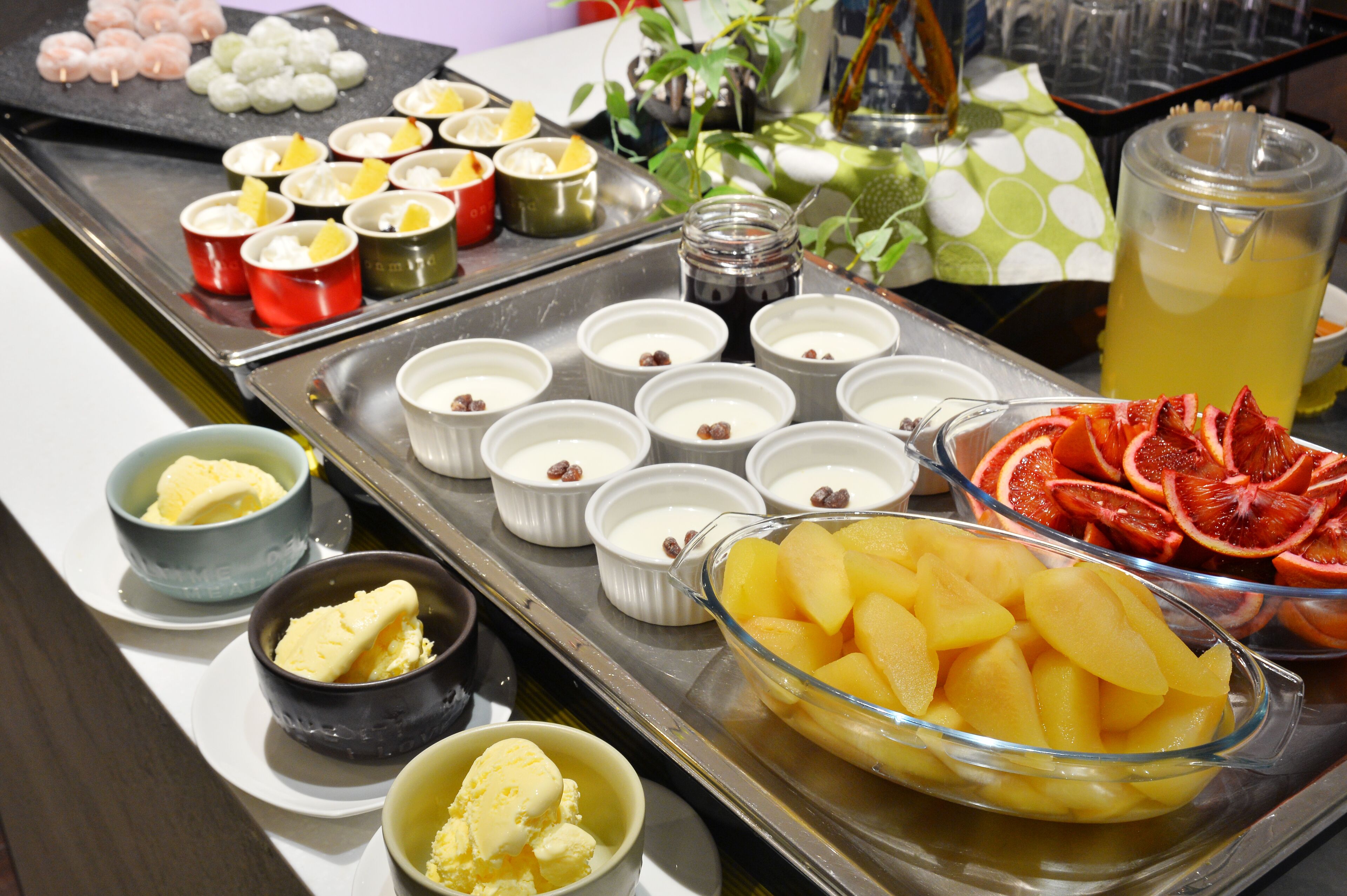 Un bufé con diversos alimentos, como frutas, postres y bebidas.