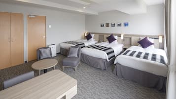 Een hotelkamer met twee bedden, een bureau, een stoel en een tafeltje.
