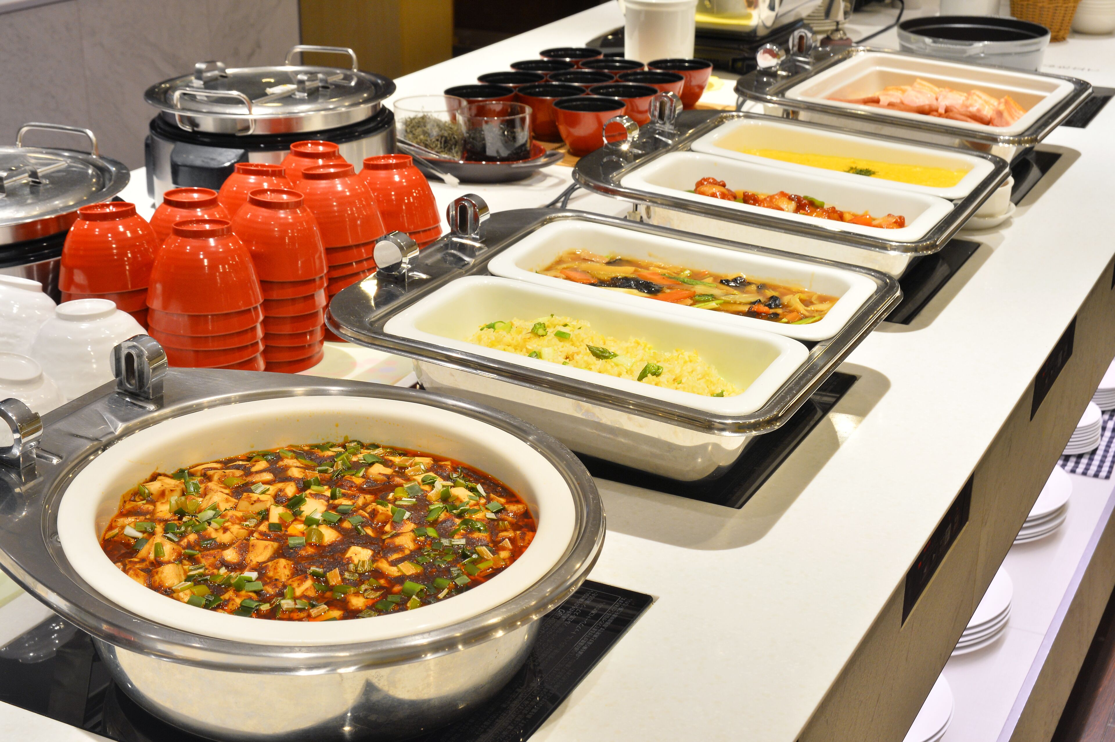 Un bufé con diversos alimentos presentados en recipientes.