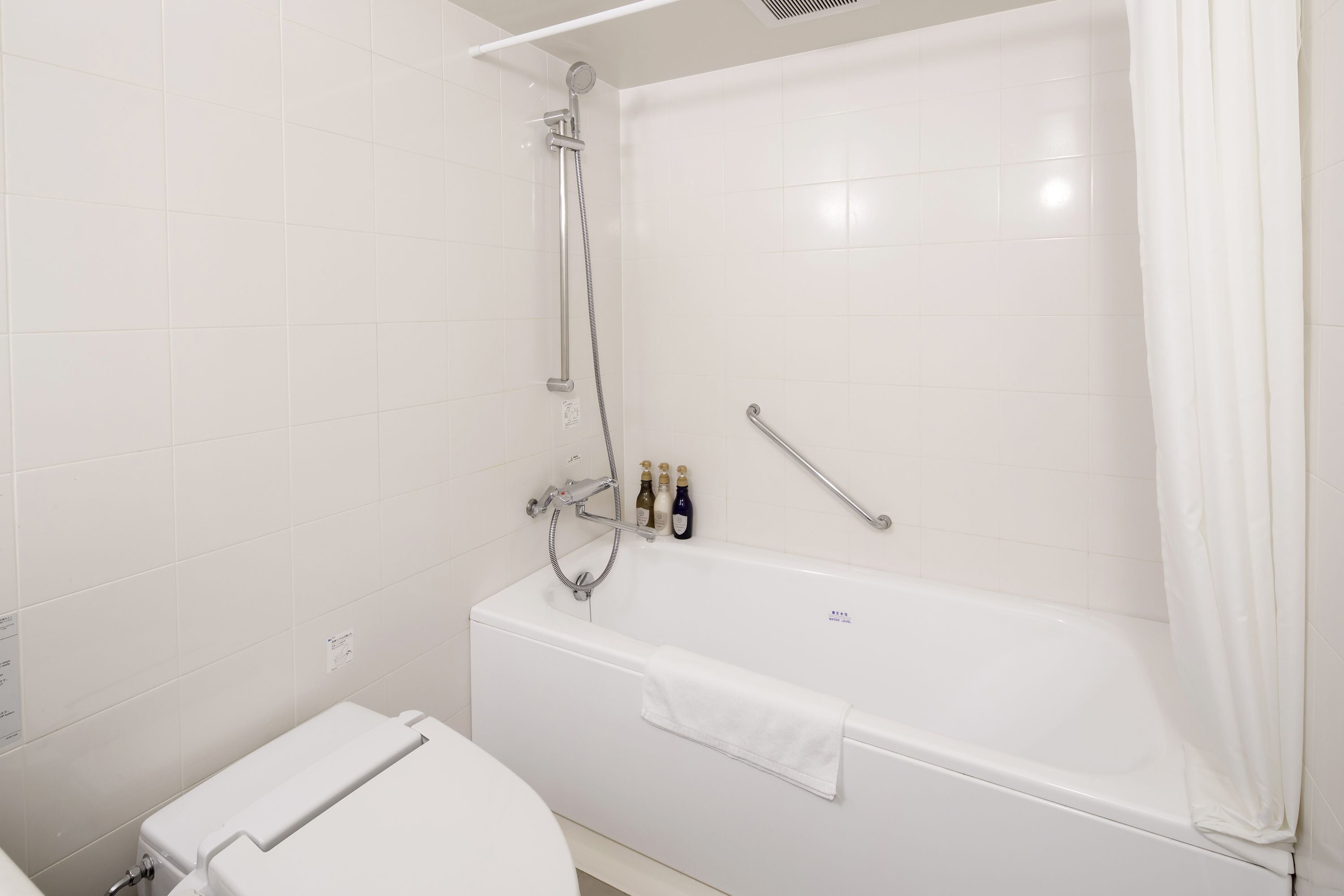 A modern bathroom with a bathtub, a toilet, and a shower.