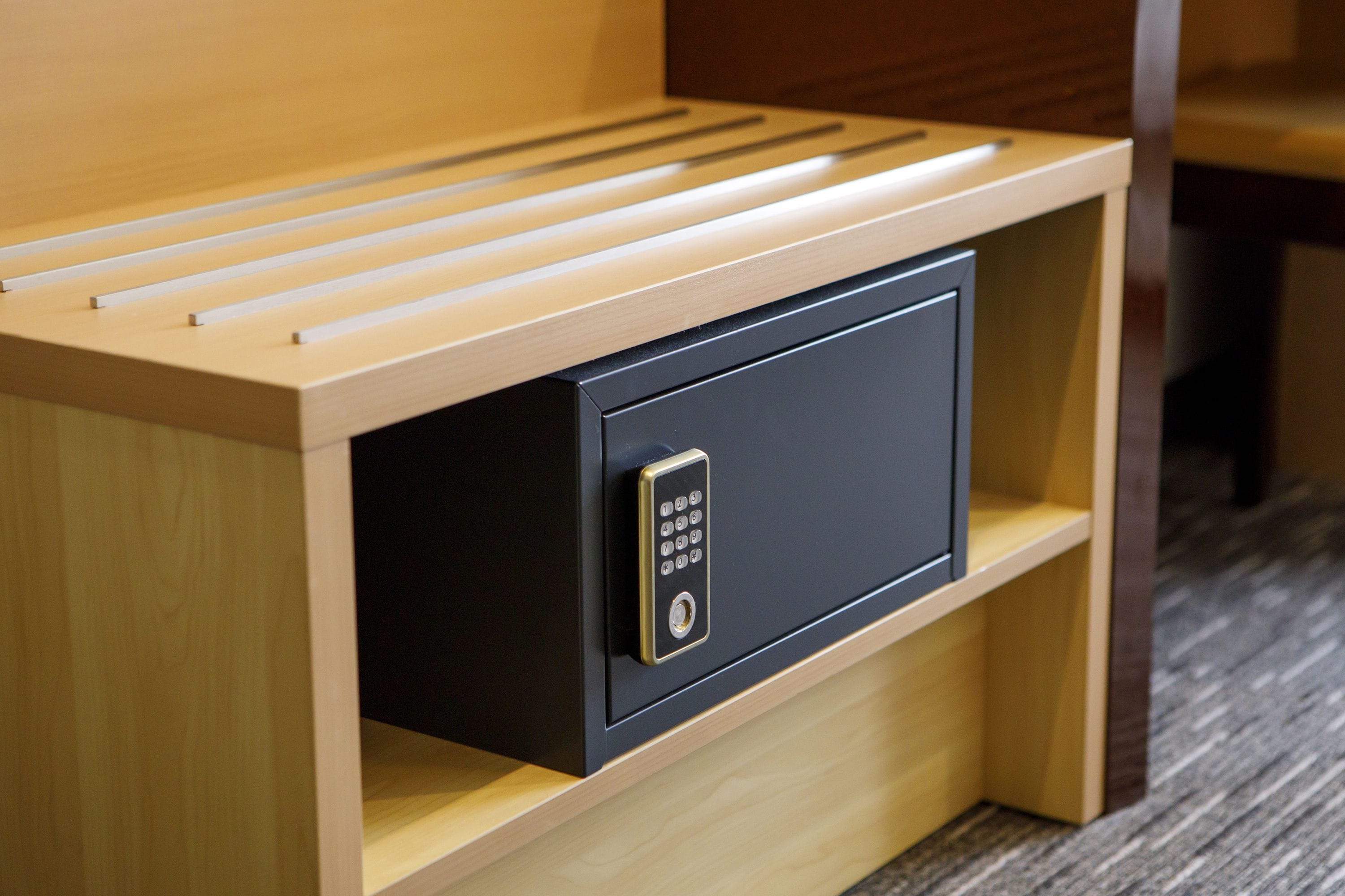 A wooden bedside table with a built-in safe.