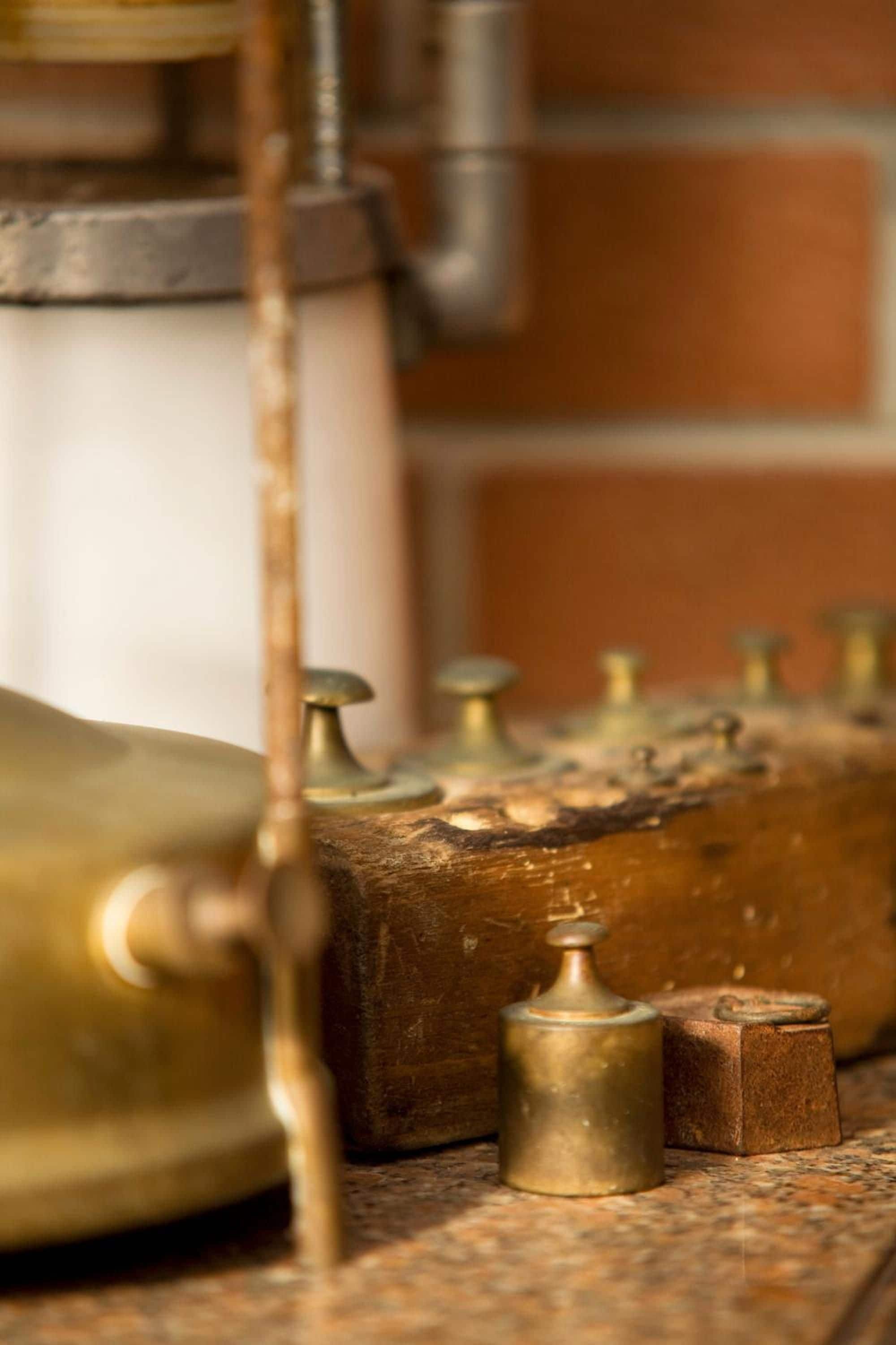 Een koperen destillatie-apparaat met een glazen vat en een metalen buis.