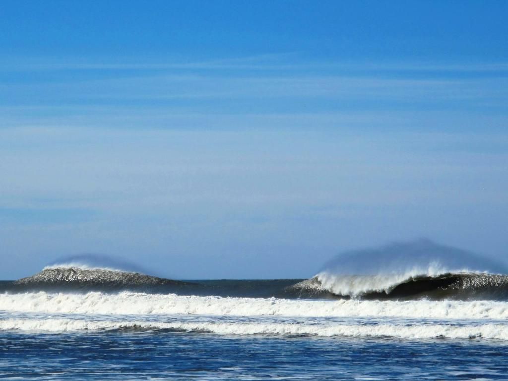 A beach with waves and a clear sky.