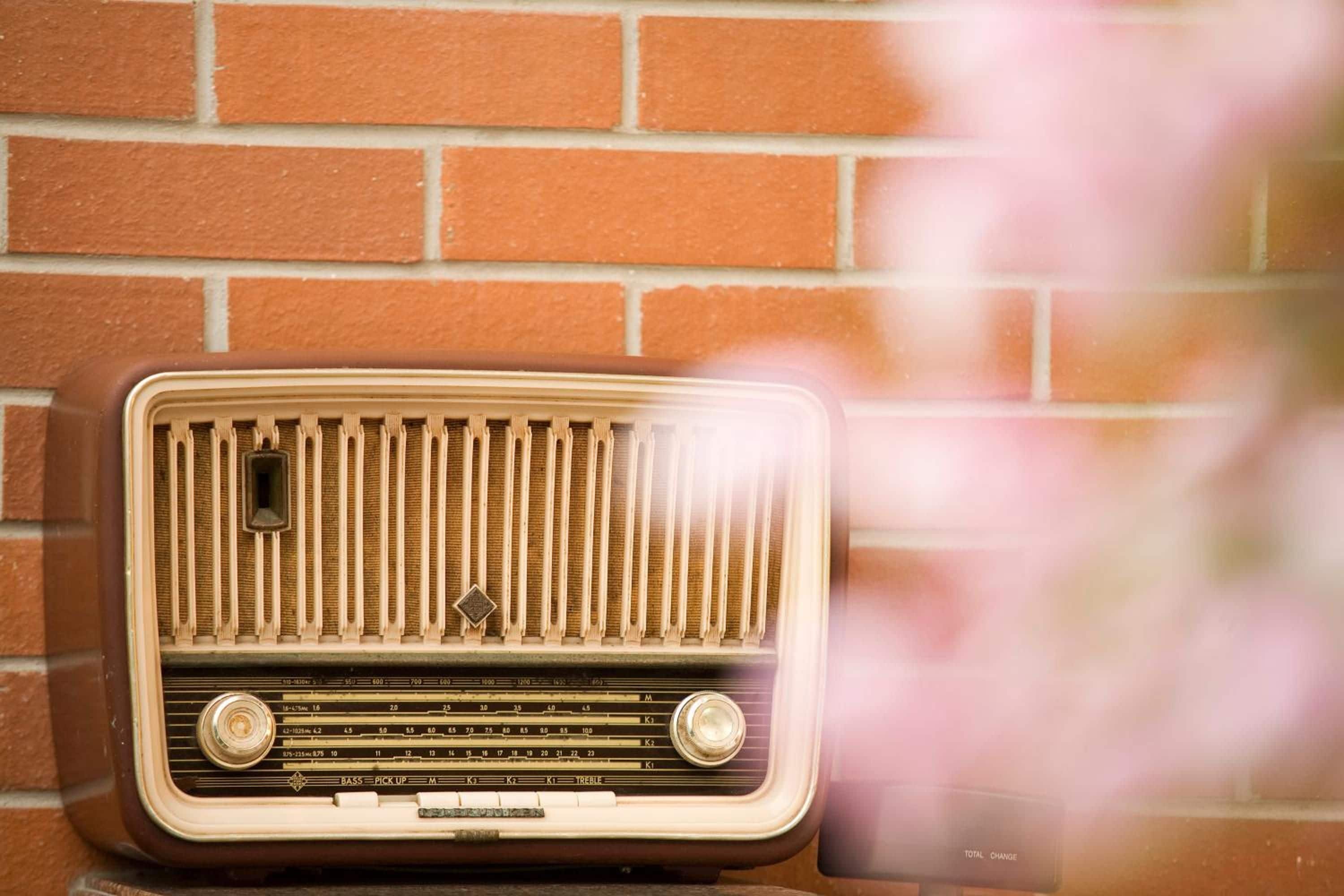 Una radio antigua frente a un muro de ladrillo.