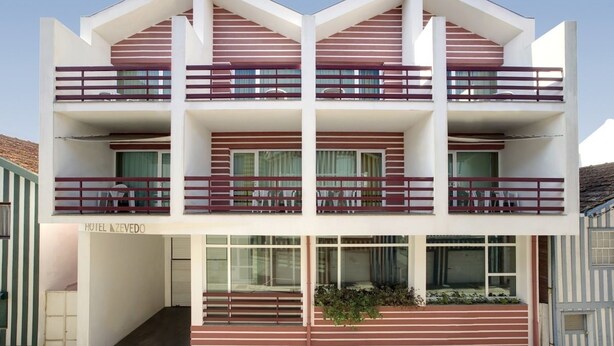 A hotel with a modern design, featuring a two-story structure with balconies and large windows. - Costa Nova Hotel (Ilhavo)