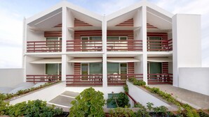 A modern multi-story building with balconies, a flat roof, and a garden area. - Costa Nova Hotel (Ilhavo)