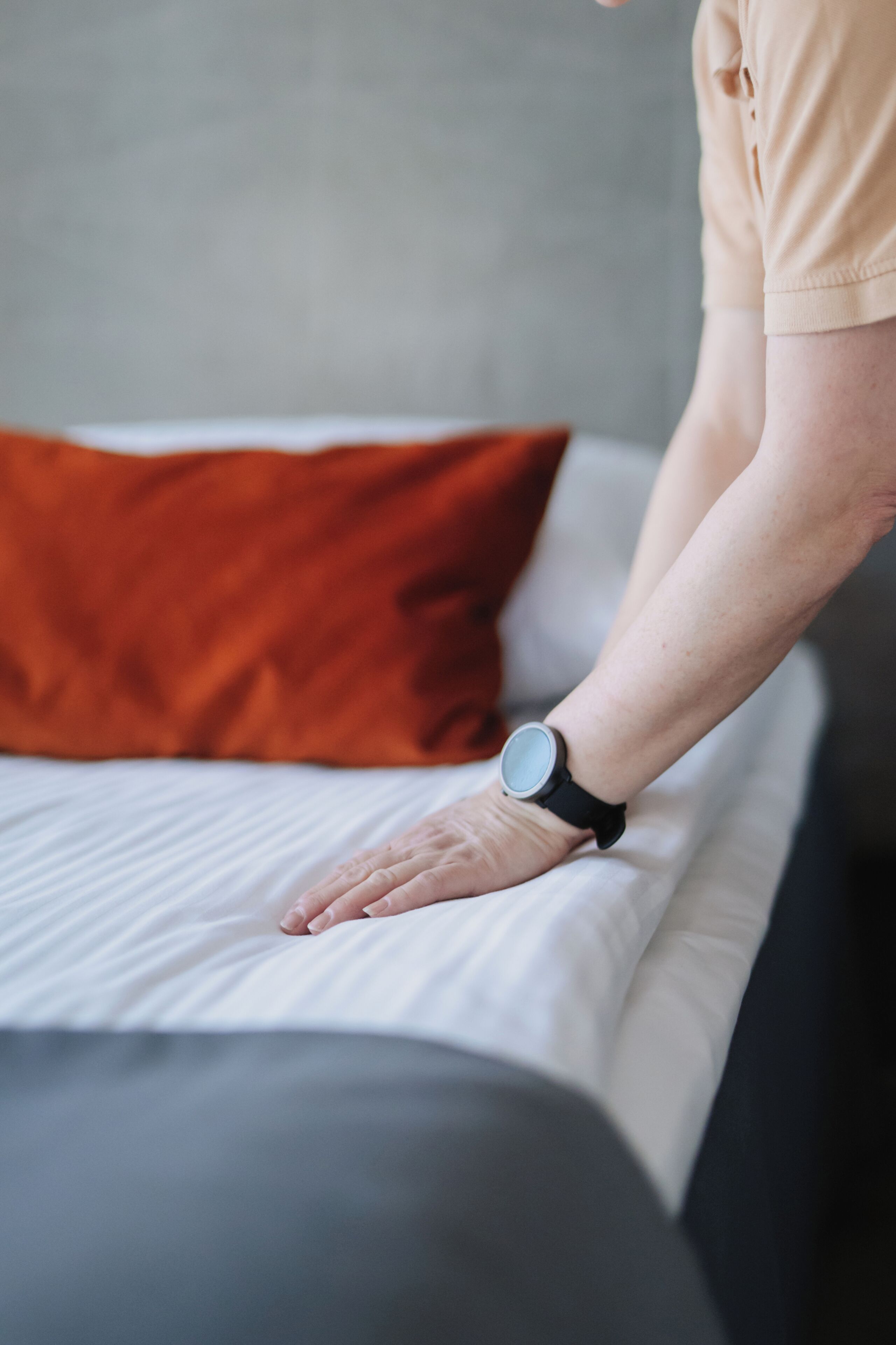 A person lying on a bed with a watch on their wrist.