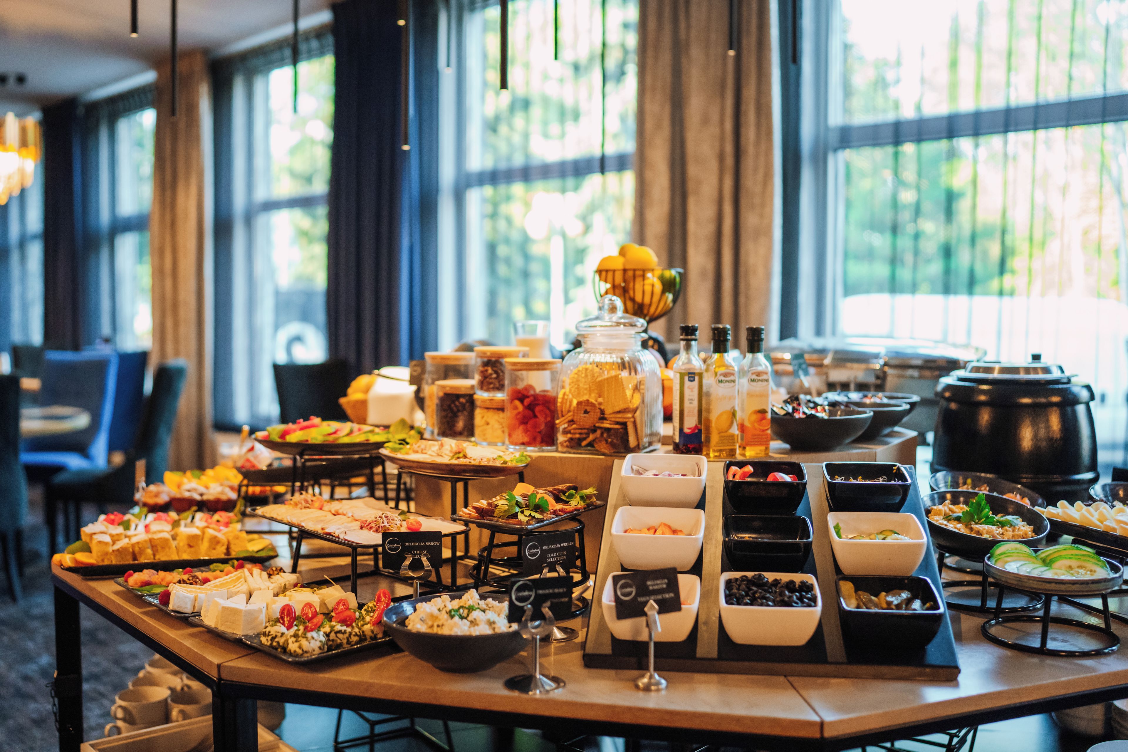 A buffet table with various food items and condiments.