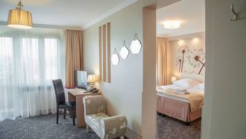 Habitación de hotel con escritorio, silla, cama y una pared con luces decorativas.