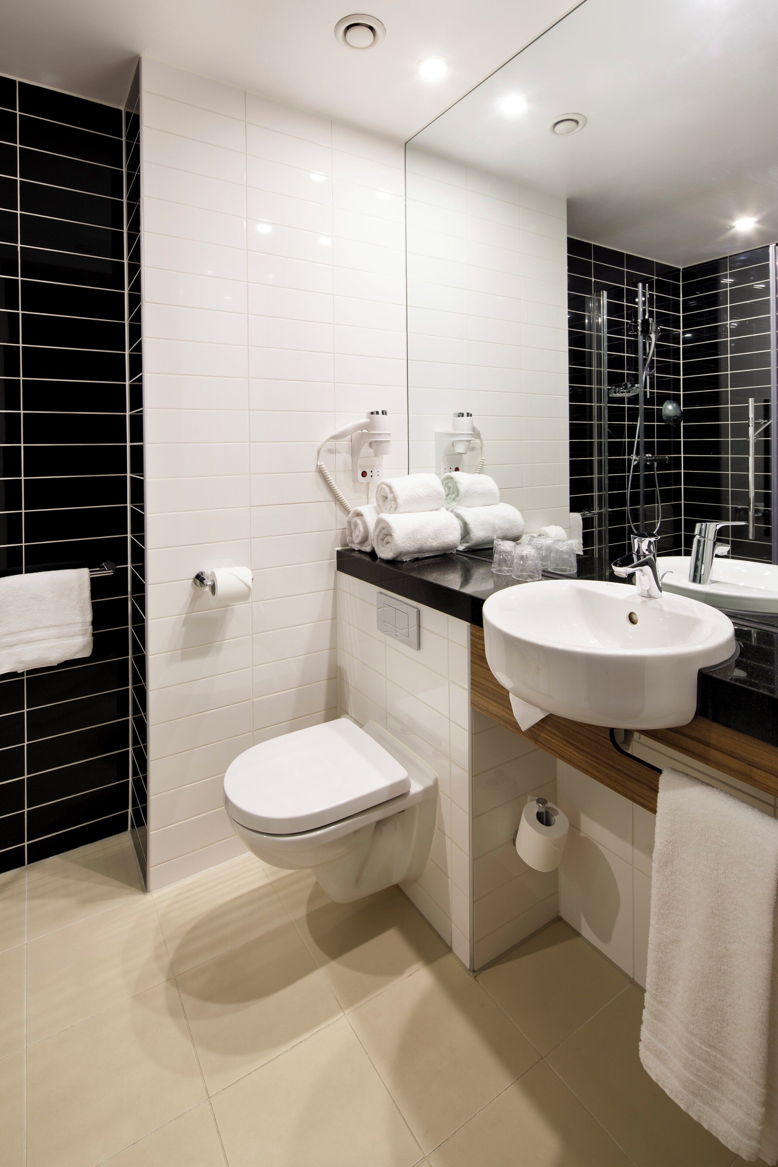 Ein modernes Badezimmer mit Toilette, Waschbecken und Handtuchhalter.