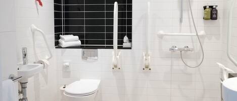 Un baño moderno con inodoro, lavamanos y ducha.