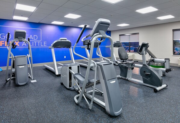 A gym with various exercise machines, a blue wall with motivational text, and a window with a view of a blue car. - Holiday Inn Express Hotel & Suites Minneapolis SW - Shakopee by IHG (Shakopee)