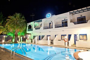 A hotel with a swimming pool, multiple balconies, and a sign indicating it is a hotel. - Ariadni Blue Hotel (Sithonia)