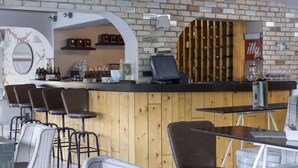 A bar area with wooden paneling, a counter with a cash register, and a wine rack. - Leto Boutique Hotel (Agrinio)