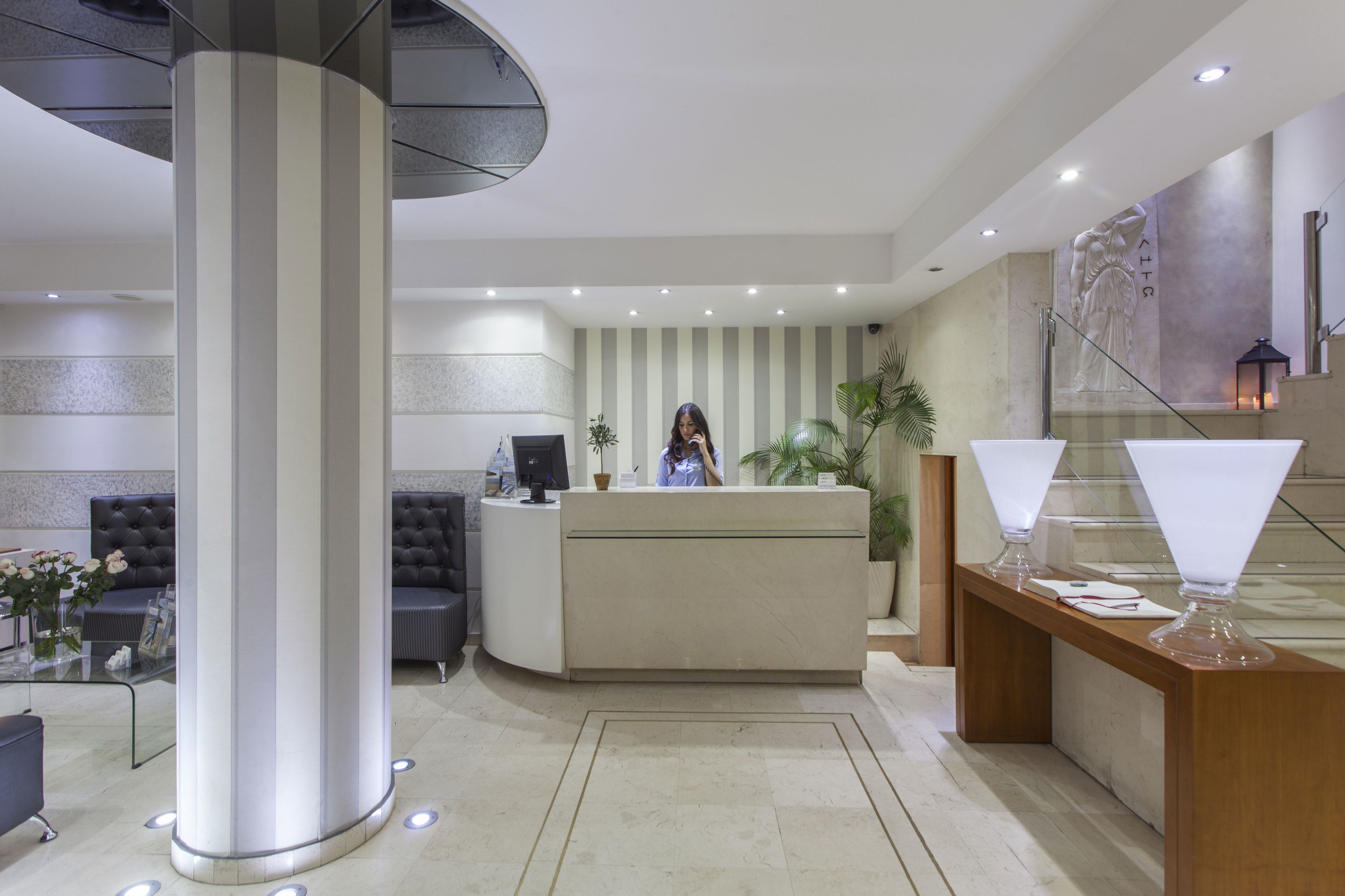 A modern reception area with a reception desk, seating area, and a large column.