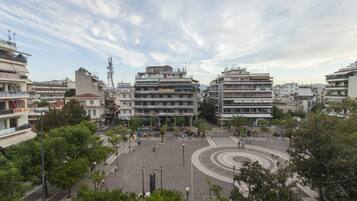 Une place de ville avec des bâtiments, des arbres et un monument circulaire.