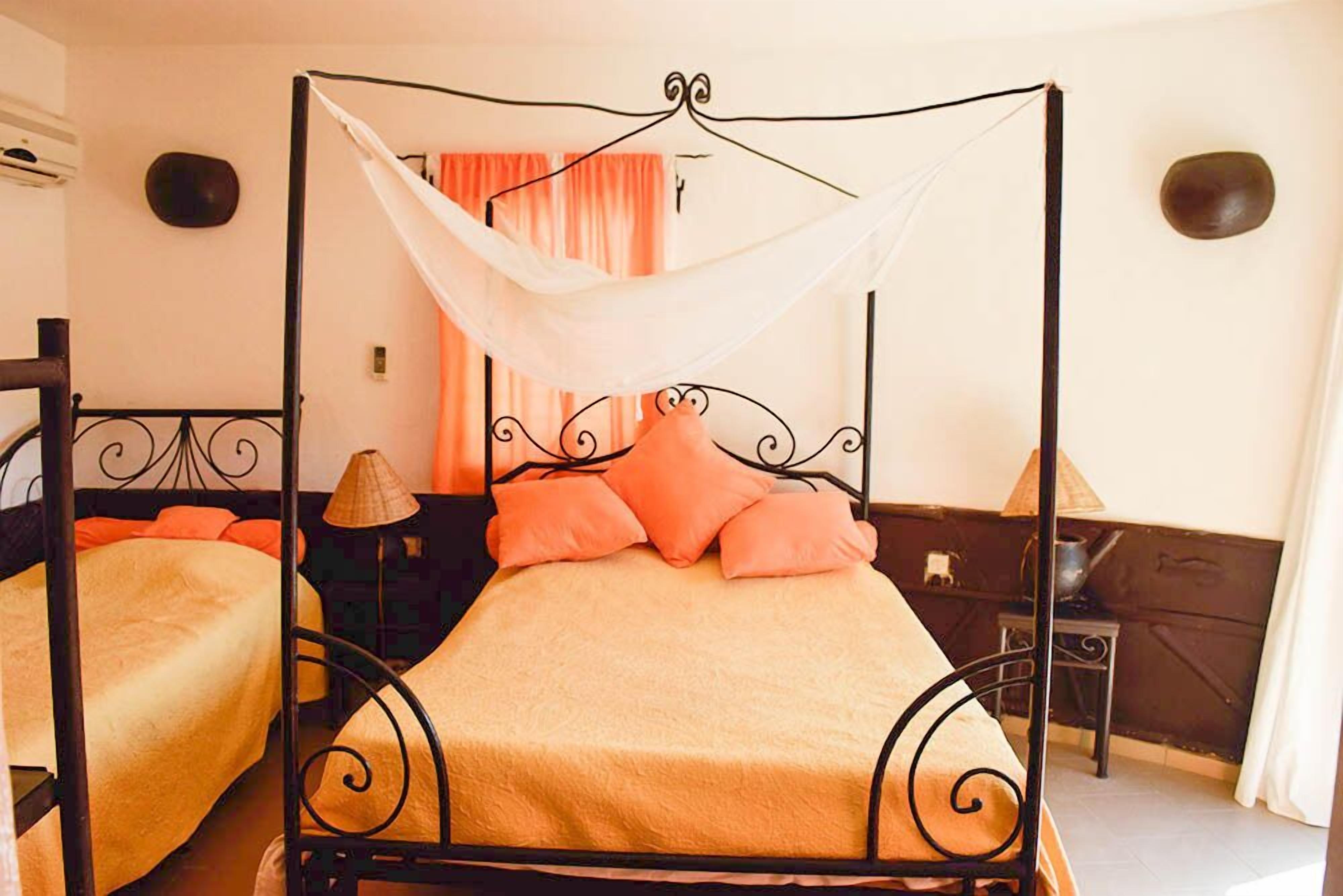 A four-poster bed with a canopy, two bedside tables, and a nightstand.