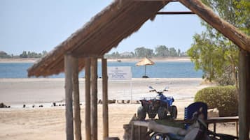 Di pantai, kursi berjemur, payung pantai, dan handuk pantai