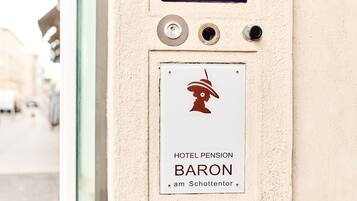 Entrada de un hotel con un cartel que indica 'HOTEL PENSION BARON am Schottentor'.