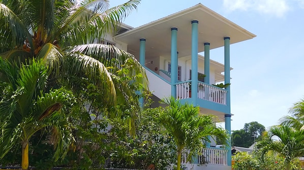 A multi-story building with a balcony, surrounded by lush greenery. - La Villa Therese (Mahé Island)