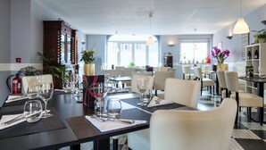 A dining area with tables set for service, including wine glasses and cutlery. - Logis Hôtel Restaurant Du Commerce (Estang)