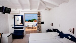 A bedroom with a bed, a desk, a television, and a view of the outdoors. - Potidea Golden Beach Hotel (Nea Propontida)