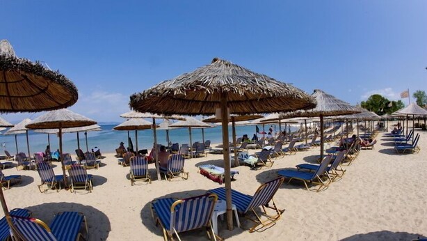 A beach with sun loungers and thatched umbrellas. - Potidea Golden Beach Hotel (Nea Propontida)