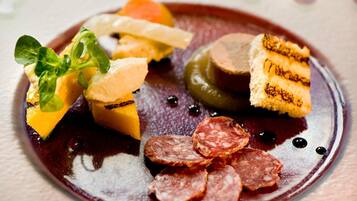 A gourmet dish with various meats and vegetables on a plate.