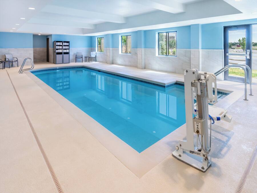 A swimming pool with a lifeguard chair and a changing room.
