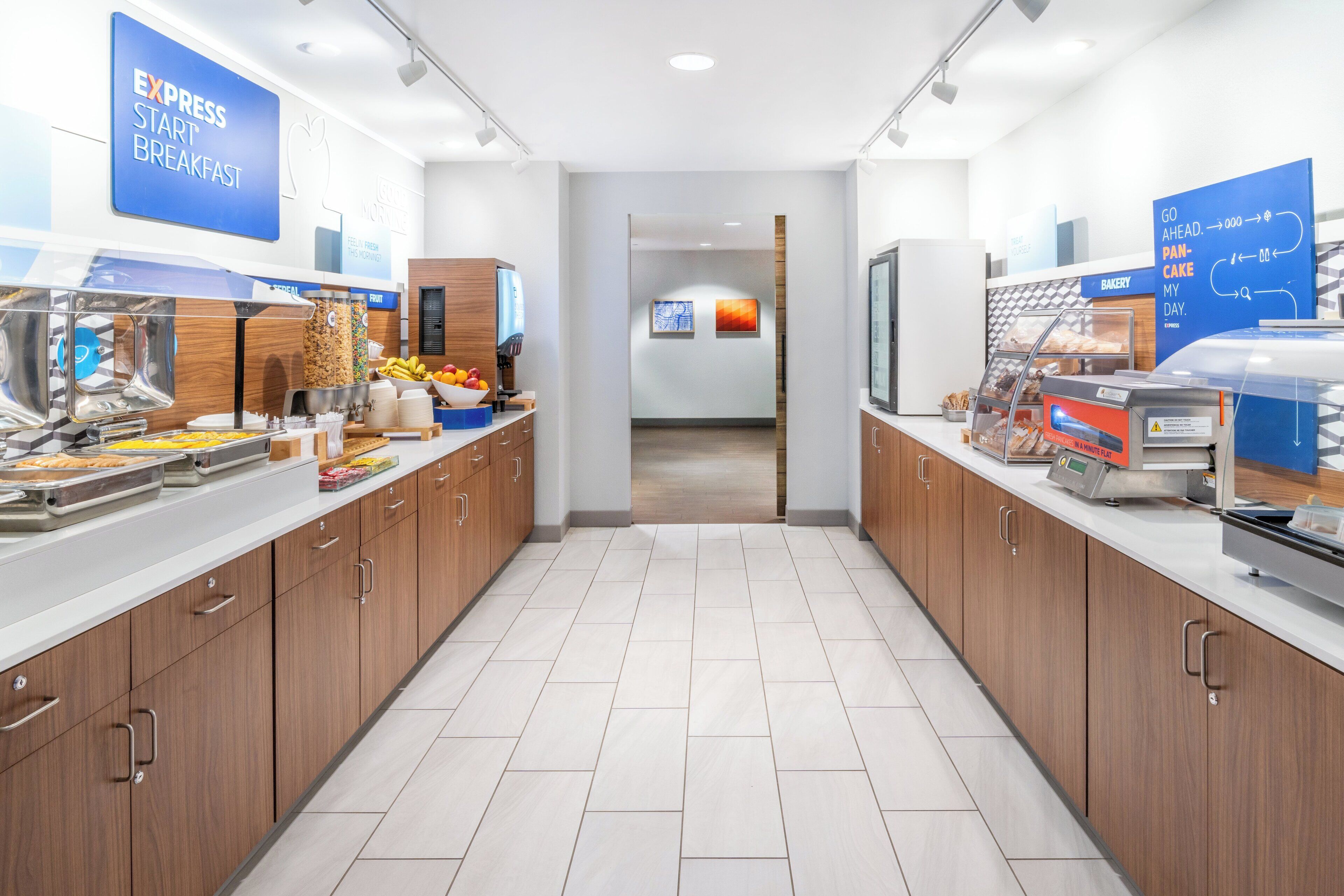 Een moderne ontbijtruimte met bedieningsstations, een bakkerij en een goed zicht op de gang.